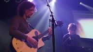 Bandmitglied von Porcupine Tree spielt Gitarre auf der Bühne