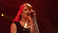 Garbage: Sängerin mit roten Haaren und gestreiftem Handschuh singt ins Mikrofon