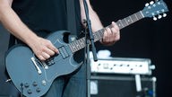 Gitarrist von Kettcar spielt einen Es-moll Akord auf seiner Gibson SG in Schwarz