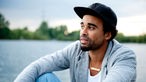 Sänger "Patrice" blickt Gedanken verloren über den Fühlinger See
