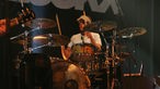 Steffen Wilmking von den H-Blockx hat eine beige Kappe auf und spielt Schlagzeug beim Underground Festival 2007