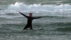 Tamina Kallert im Neoprenanzug auf einem Surfbrett im bewegten Meer