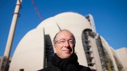 Der Architekt Paul Böhm posiert vor der Baustelle der Zentralmoschee in Köln