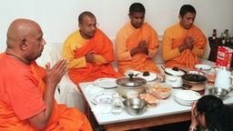 Mönche beten vor dem Essen im Speiseraum