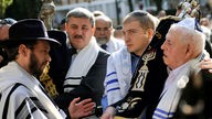 Gemeindemitglieder tragen Thorarollen in die neue Mainzer Synagoge