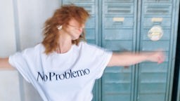 Mit ausgebreiteten Armen und einem T-shirt mit der Aufschrift No Problemo blickt Franziska Knost zur Seite.