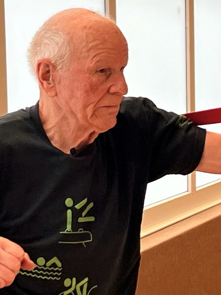 Älterer Mann, der mit Gymnastikbändern seine Arme trainiert