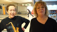 Frau und ein junger Mann mit Behinderung auf der Bowlingbahn