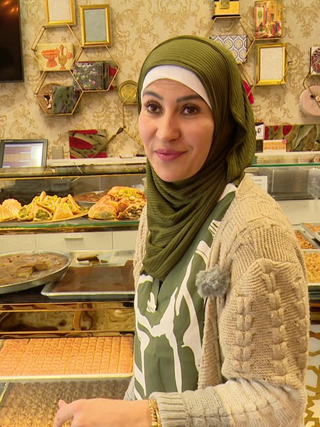 Hanadi el Khatib steht vor der Theke in ihrer Bäckerei "Hanadi Sweets"