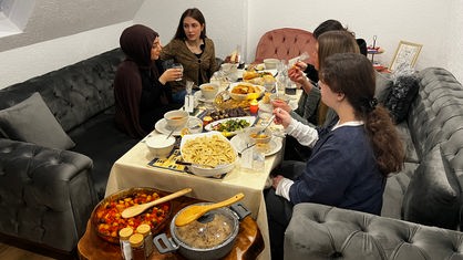 Irem Altunay isst gemeinsam mit Freunden und Familie nach Sonnenuntergang.