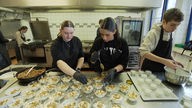 Mehrere Schüler bereiten in der Schulküche der Gesamtschule Weierheide in Oberhausen die Desserts zu