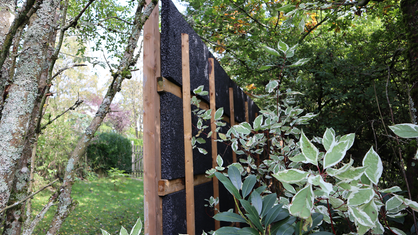 Foto von einem Lärmschutzzaun aus Holz und Styropor in einem Garten