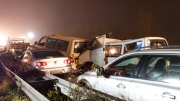 Verunglückte Fahrzeuge stehen an der Unfallstelle einer Massenkarambolage auf der A31