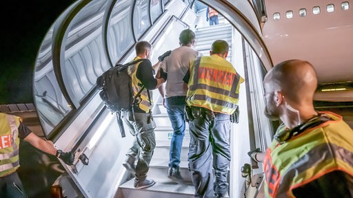 Sachsen, Leipzig: Polizeibeamte begleiten einen Afghanen auf dem Flughafen Leipzig-Halle in ein Charterflugzeug.