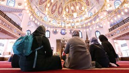 Vier Frauen sitzen in der DITIB-Merkez-Moschee in Duisburg.