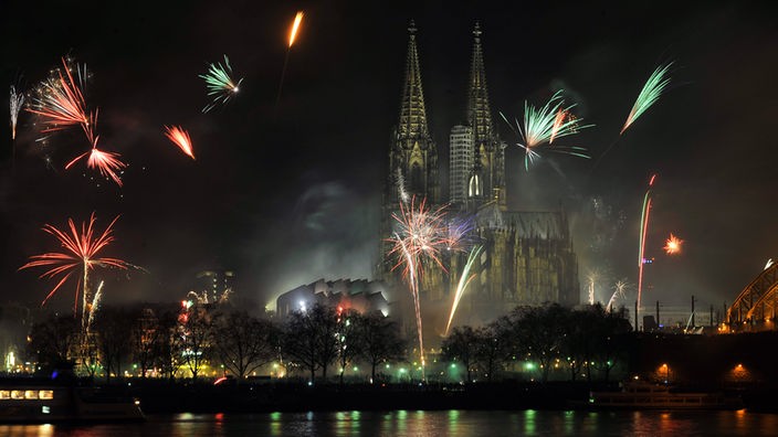 Raketen steigen in der Nacht beim Silvester-Feuerwerk vor dem Dom in Köln in den Himmel