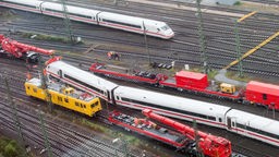 Ein entgleister ICE wird im Hauptbahnhof in Dortmund  geborgen, während ein anderer Zug vorbeifährt