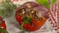 Das Bild zeigt das fertige Gericht "Gefüllte Paprika mit Hackfleisch, Feta und Bacon".