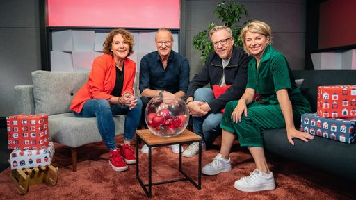 Die WDR 2 Moderatoren Sabine Heinrich, Steffi Neu, Jan Malte Andresen und Thomas Bug auf zwei Sofas sitzend, drumherum mit weihnachtlicher Deko