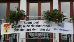 Plakat am Rathausbalkon "Augustdorf begrüßt seine rückkehrenden Soldaten von ihrem Einsatz"