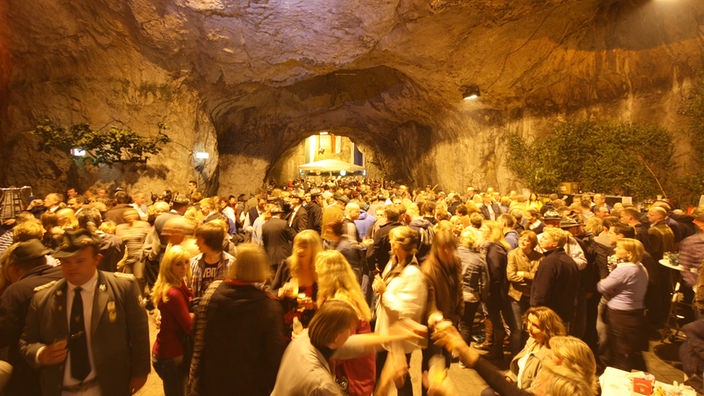 Viele Menschen in beleuchteter Höhle