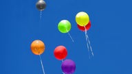 Luftballons in den Farben Rot, Gelb, Schwarz, Grüne, Lila