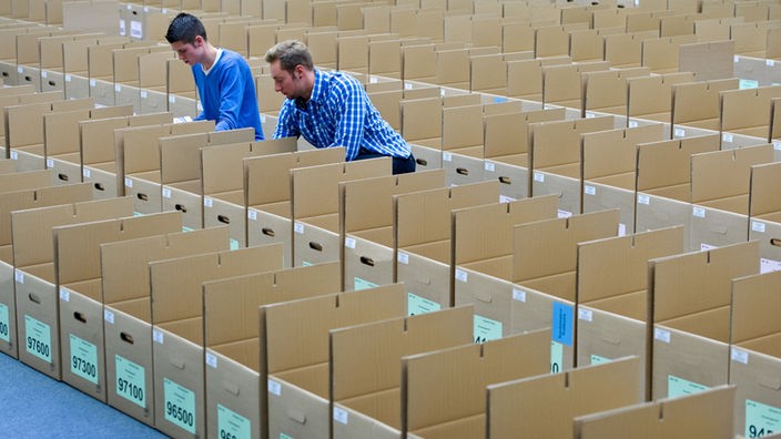 Zwei Wahlhelfer bereiten die Unterlagen für die Bundestagswahl vor