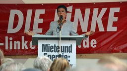 Sahra Wagenknecht steht in Köln auf einer Bühne und spricht zu den Zuhörern