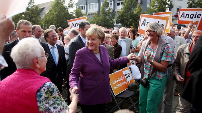 Bundeskanzlerin Angela Merkel begrüßt am 30.08.2013 in Olpe vor einem Wahlkampfauftritt die Menschen