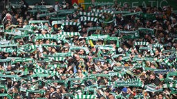 Werder Bremen Fans halten ihre Schals hoch