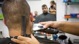 Einem Mann werden die Haare geschnitten