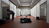 Nordrhein-Westfalen, Schwerte: Eine Journalistin filmt im Bürgersaal des Rathauses Kabinen für das Unterbringen von Flüchtlingen