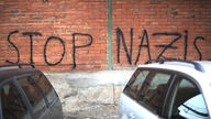 Schrift auf einer Mauer: Stop Nazis
