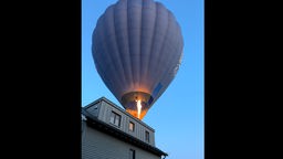 Heißluftballon streift Hausdach