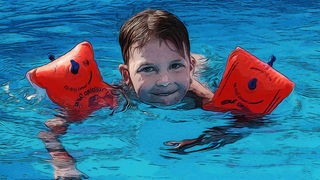 Kind im Schwimmbad mit Schwimmflügeln