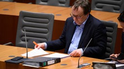 Oliver Krischer im Landtag auf seinem Platz sitzend