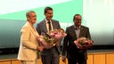 Bochums Oberbürgermeister Thomas Eiskirch steht mit Blumenstrauß auf der Bühne, nach der Wahl zum Vorsitzenden des Städtetags NRW