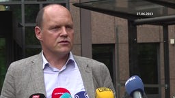 Ulf Willuhn von der Staatsanwaltschaft Köln steht vor Mikrofonen und beantwortet Fragen zur Razzia im Erzbistum Köln