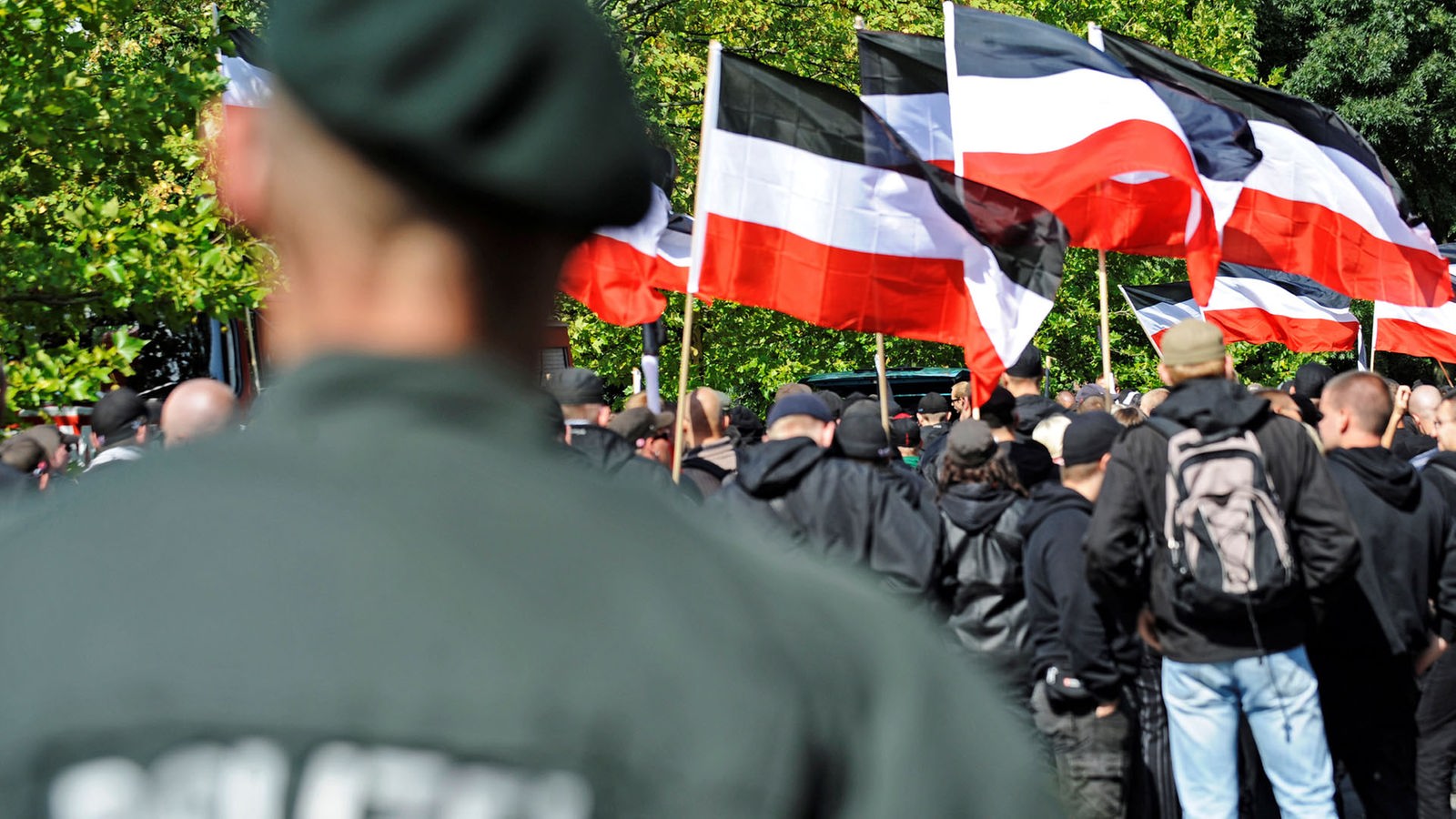 Ein Polizist beobachtet in Dortmund demonstrierende Rechtsextremisten (Aufnahme von 2009)