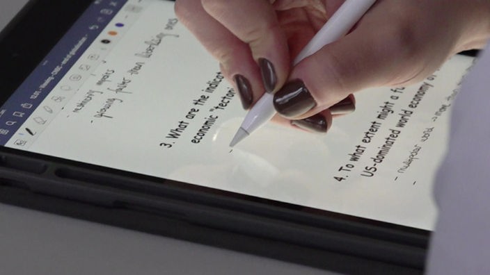Eine Schülerin schreibt auf einem iPad.