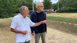 BUND-Sprecher Helmut Röscheisen und Jörg Frank begutachten die Schäden an den Uniwiesen