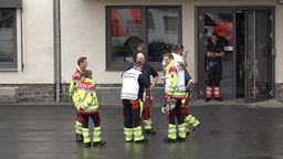 Rettungskräfte stehen auf einem Schulhof