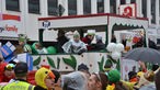 Ein großer Karnevalswagen, auf dem Mitglieder des Karnevalsvereins stehen und Kamelle werfen.
