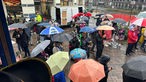 Menschen unter Schirmen feiern Karneval