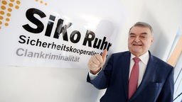 Herbert Reul (CDU) präsentiert bei der Vorstellung der "Sicherheitskooperation Ruhr zur Bekämpfung der Clankriminalität" das Schild der Dienststelle in Essen (10.12.2019).