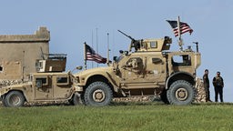 Zwei Fahrzeuge der US-Armee stehen vor einem amerikanischen Stützpunkt in der Nähe von Manbidsch (Syrien)