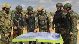 Von der Türkei unterstützte Streitkräfte der «Freien Syrischen Armee» gucken auf eine Karte während eines militärischen Manövers in Vorbereitung auf einen möglichen türkischen Angriff auf kurdische Kämpfer in Syrien