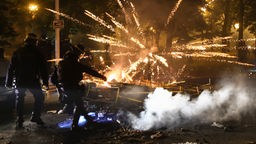 Krawalle auf den Straßen Nanterres, Polizisten in voller Montur vor explodierenden Feuerwerkskörpern