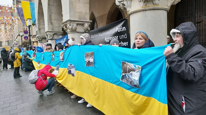 Menschen mit der Flagge der Ukraine vor dem Rathaus in Münster.