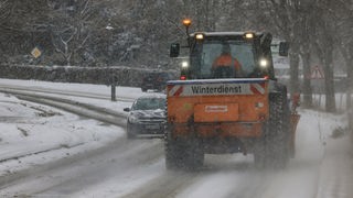 Bad Honnef: Ein Winterdienst fährt über eine Landstrasse. Im südlichen Teil von Nordrhein-Westfalen hat Schneefall eingesetzt.